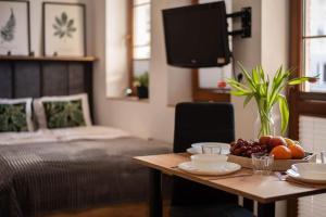 a room with a table with fruit on it with a bed at Place4You in Ostróda