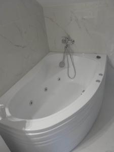 y baño blanco con bañera blanca. en Izabella Guest House, en Săcele