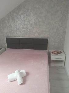 a cross laying on top of a pink bed at Izabella Guest House in Săcele +95 photos