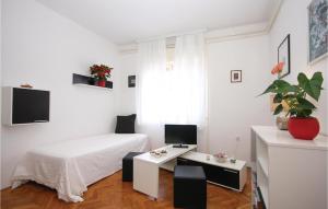 a white bedroom with a bed and a table at Awesome Apartment In Vodnjan With 2 Bedrooms And Wifi in Vodnjan