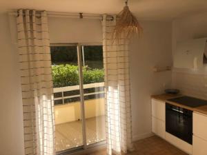 a kitchen with a sliding glass door to a balcony at Appartement Biarritz Sud in Biarritz