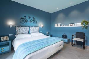 niebieska sypialnia z łóżkiem i rowerem na ścianie w obiekcie Draisina Bike Apartments DUE w mieście Oleggio Castello