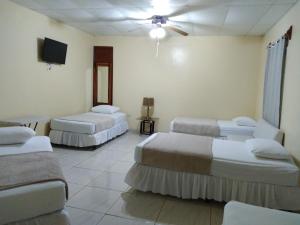 um quarto com 3 camas e uma televisão de ecrã plano em Hotel Dalinky em San Jorge