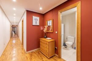 a bathroom with a toilet and red walls at Txurruka - baskeyrentals in Mutriku +42 photos