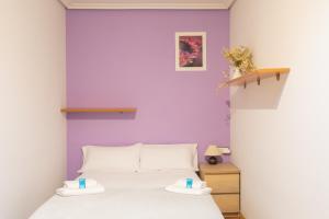 a bedroom with a bed with a purple wall at Txurruka - baskeyrentals in Mutriku