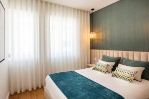 1 dormitorio con 1 cama blanca grande con almohadas en Casa das Musas, en Oporto