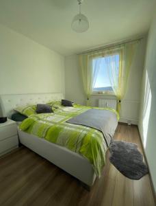 a bedroom with a large bed and a window at Svit apartment High Tatras in Svit