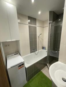 łazienka z umywalką, wanną i toaletą w obiekcie Svit apartment High Tatras w Świcie