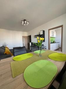a dining room table with green mats on top of it at Svit apartment High Tatras in Jezersko