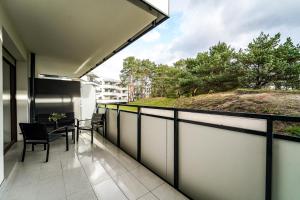 a balcony with a table and chairs on it at apartament MT2 bursztynowe osiedle in Jantar
