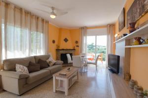 ein Wohnzimmer mit einem Sofa und einem TV in der Unterkunft Club Villamar - Benji in Vidreres