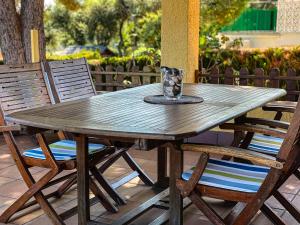 una mesa de madera y sillas en un patio en Club Villamar - Rubia, en Calonge