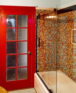 La salle de bains est pourvue d'une porte rouge et d'une douche. dans l'établissement Beautiful, Historic Family Home near Lake Merritt, à Oakland
