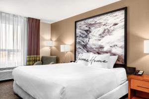 uma grande cama branca num quarto de hotel em Home Inn and Suites Lloydminster em Lloydminster