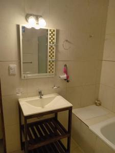 a bathroom with a sink and a tub and a mirror at DEL SOL APART TERMAL in Termas de Río Hondo