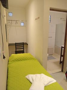1 dormitorio con cama verde y baño en DEL SOL APART TERMAL en Termas de Río Hondo