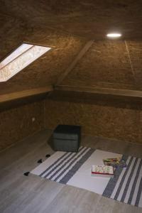 an attic room with a television and a window at Perto do Mar, Alojamento Local - Espaço T2 privativo in Vagos
