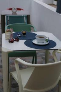 a table with a cup of coffee and a pair of glasses at Perto do Mar, Alojamento Local - Espaço T2 privativo in Vagos