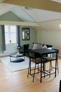 een woonkamer met een zwarte tafel en stoelen bij Charming 1-Bed loft in Caerleon in Newport
