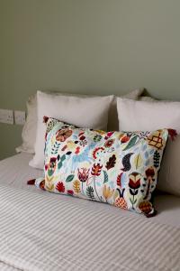 a bed with a pillow with a flower pattern on it at Charming 1-Bed loft in Caerleon in Newport