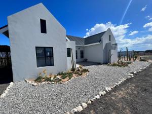a white house with a gravel driveway at Casa Felice in Langebaan