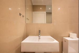 a bathroom with a white sink and a toilet at Cool, Quiet Notting Hill 2 BED APT in London