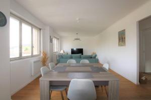 ein Wohnzimmer mit einem Tisch und einem blauen Sofa in der Unterkunft Joli appartement au calme in Lay-Saint-Christophe