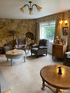 a living room filled with furniture and a stone wall at Killerby Cottage Farm in Scarborough