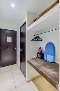 Habitación con banco y silla azul en First Inn Hotel & Business en Texcoco de Mora