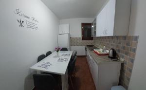 a small kitchen with a table and a refrigerator at Apartman Vukoja Pakostane in Pakoštane +3 photos