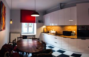 a kitchen with a wooden table and a dining room at Apartament Cafe Belg in Częstochowa