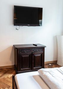 a flat screen tv on a wall above a bed at Apartament Cafe Belg in Częstochowa