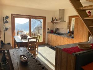 una cucina con tavolo e vista sulle montagne di Chalet Gorret a Torgnon