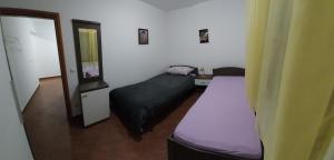 a small room with two beds and a mirror at Apartman Vukoja Pakostane in Pakoštane