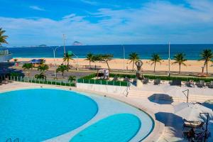 a view of a swimming pool and the beach at Hotel Nacional Vista Mar c/ Banheira in Rio de Janeiro