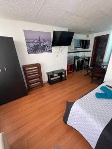 Habitación con 1 dormitorio con 1 cama y cocina en Apt estudio calle97302, en Bogotá