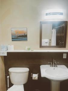 a bathroom with a white toilet and a sink at Pacific Blue Inn in Santa Cruz