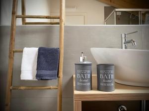 a bathroom with a sink and two containers on a shelf at Palmamore in Palmanova