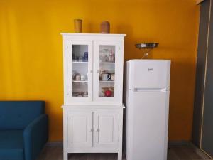 - une armoire blanche à côté d'un réfrigérateur blanc dans l'établissement ALAMANDA STUDIO LE GRAU DU ROI -, au Grau-du-Roi