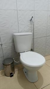 um WC branco numa casa de banho com uma lata de lixo em Pousada Santo Amaro em Santo Amaro