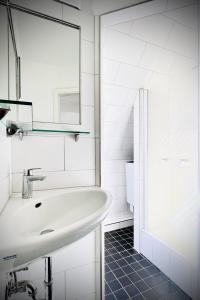 a white bathroom with a sink and a mirror at Das Stader Nest in Stade