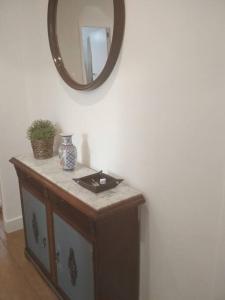 a vanity with a mirror on a white wall at Ideal Apartamento para familia con wifi in Sagunto