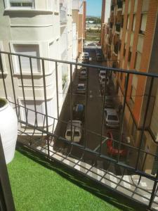 un balcón con vistas a una calle con coches aparcados en Ideal Apartamento para familia con wifi, en Sagunto
