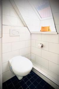 a white bathroom with a toilet and a shelf at Das Stader Nest in Stade