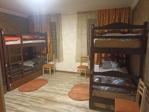 een kamer met 2 stapelbedden en 2 stoelen bij Aragats Hostel & Guest House in Gjoemri
