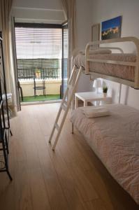 sypialnia z 2 łóżkami piętrowymi i balkonem w obiekcie Habitación privada Granada centro w Grenadzie