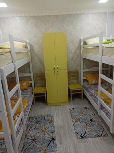 a room with three bunk beds and a yellow cabinet at Aragats Hostel & Guest House in Gyumri