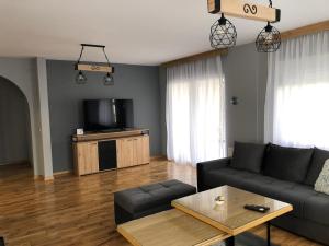 a living room with a couch and a tv at Vila ISKRA in Novi Sad