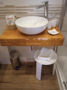 un lavandino bianco su un bancone in legno in bagno di Room and Breakfast San Marco a Bologna