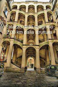 a large building with columns and ceilings with cars parked at DG Sweet Home in Naples